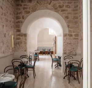 Modern minimalist cafe interior featuring stone walls and concrete flooring.