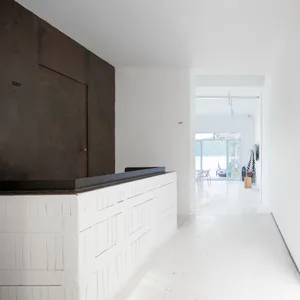 A minimalist commercial interior showcasing white concrete walls and flooring.