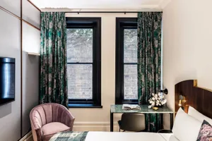 A modern bedroom featuring textured curtains and a marble-topped table.