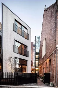 A modern building with white brick exterior and large windows.