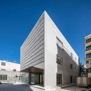 Modern building with a concrete facade and grid-like window pattern.