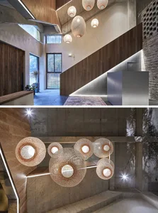 A modern hallway with concrete walls, wooden accents, and large woven pendant lights hanging from the ceiling.