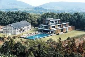 Modern residential building with a pool and greenery.