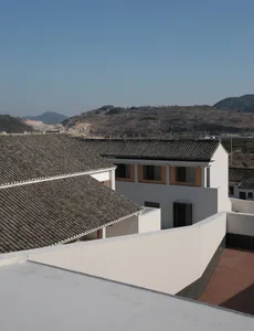 Modern residential building with white tiled roof and white walls.