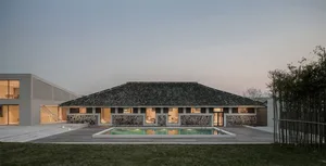 Modern residential building with stone walls, wooden accents, and concrete flooring.