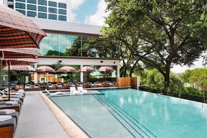 Swimming pool with glass walls and lounge chairs nearby
