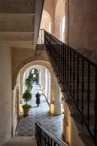 A hotel hallway with stone flooring and brick walls.