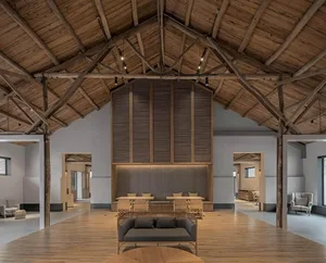 Industrially styled lobby with wooden furniture and walls, featuring high ceilings and exposed beams.