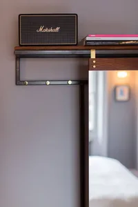 A minimalist, industrial-style stack of books featuring a black Marshall speaker on top.