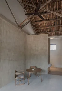 A minimalist residential interior featuring concrete and wooden materials.