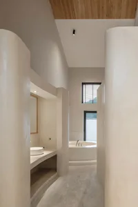 A modern bathroom with a concrete floor and a bathtub.