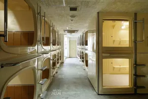 A modern capsule hotel with multiple pods, each featuring a bed and personal space.
