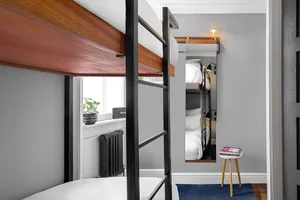 A modern industrial-style bedroom featuring metal bunk beds.