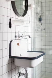 A minimalist bathroom with ceramic tile and glass features.