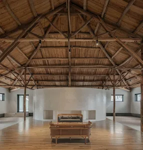 Modern minimalist interior design featuring exposed wooden beams, a white wall, and minimalist furniture.
