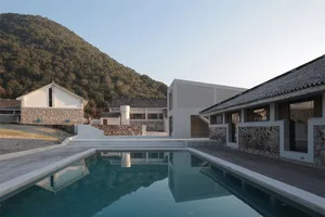 Modern residential architecture featuring concrete, wood, and stone materials.