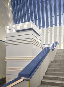 A modern staircase with white concrete steps and a blue acrylic handrail.