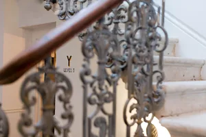 Close-up of ornate wrought iron staircase railing and wooden banister.