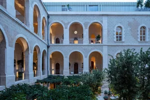 A modern interior space featuring neoclassical architecture with stone walls and arches.