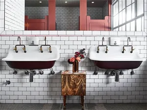 Industrial-style bathroom with concrete sinks and art deco design elements.