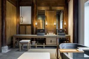 Modern minimalist bathroom with wooden walls and stone sink, featuring a rustic yet contemporary design.