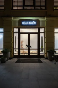 A modern, minimalist building entrance featuring large glass doors.