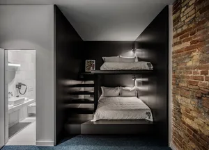 A modern bedroom with industrial elements, featuring concrete walls and a bunk bed design.