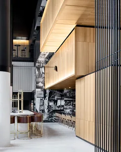 Modern cafeteria interior with wooden panels, metal railings, and concrete floors.