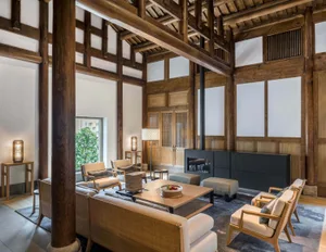 Modern living room with wooden beams, leather armchairs, and fabric seating.