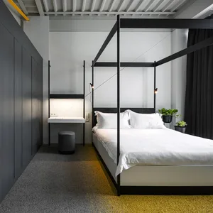 A modern minimalist bedroom with black sheets, white pillows, and a yellow floor.