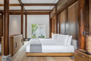 A modern minimalist bedroom featuring wooden beams and a large window