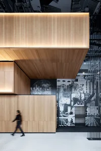 A modern office lobby with wooden walls and an artistic mural on the wall.