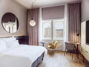 Large, modern residential bedroom featuring textured wood flooring and comfortable soft textiles.