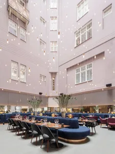 Photo of a modern restaurant interior with textured pink walls and hanging lights.