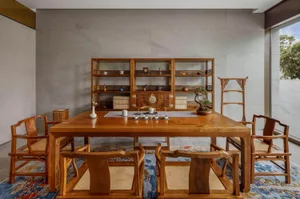 A traditional living room featuring wooden furniture and a tea table setup.