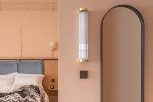 A modern bedroom showcasing metallic arch lighting and a sleek mirror.