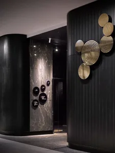 A modern hotel lobby featuring marble and black wood elements.