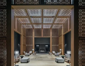A modern hotel lobby featuring wooden materials and a high ceiling with intricate designs.