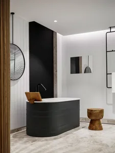 Modern bathroom featuring a black freestanding bathtub with wood accents and minimalist design elements.