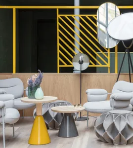 A modern living room featuring stylish furniture, a yellow table, and geometric design elements.