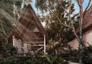 A modern house with a thatched roof and glass walls surrounded by tropical vegetation.
