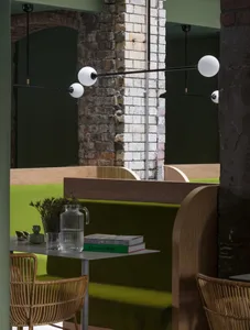 Cafe interior with wooden seating and green upholstered benches.