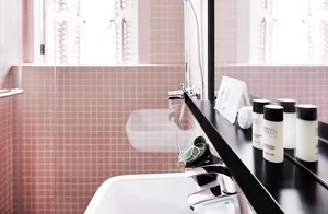 Contemporary bathroom featuring minimalist design with white fixtures and ceramic tile walls.
