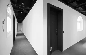 A minimalist, modern industrial corridor with concrete walls and carpets.