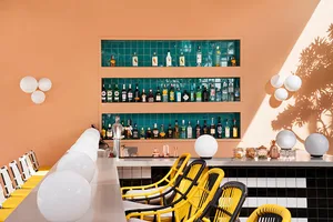 A modern bar with metal, glass, and wood surfaces.