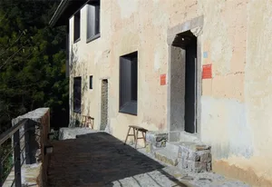 A rustic building façade with concrete and stone materials.