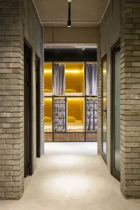Industrial-style accommodation room with concrete walls and bed pods in a hostel.