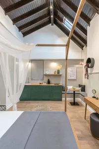 A minimalist residential interior featuring wooden furniture, concrete walls, and fabric curtains.
