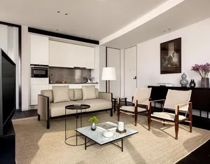 Minimalist residential living space featuring neutral-toned upholstery and wooden furniture.