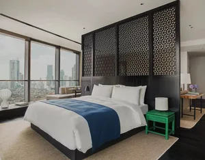 Modern bedroom featuring a glass wall, black headboard, and mixed materials, showcasing contemporary design and comfort.
